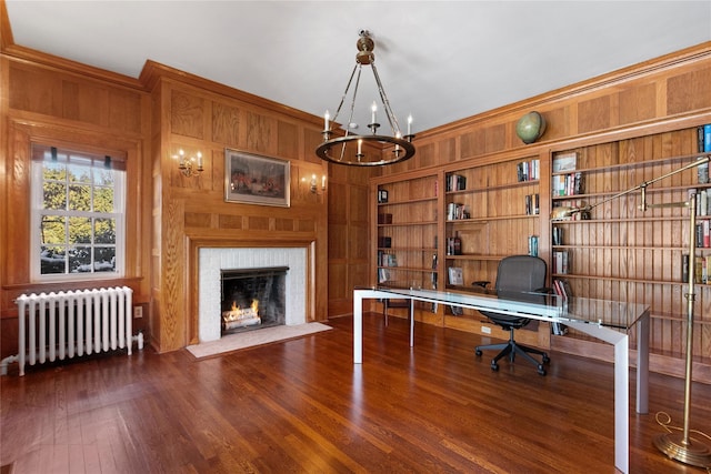 office featuring wood walls, a brick fireplace, dark hardwood / wood-style flooring, built in features, and radiator