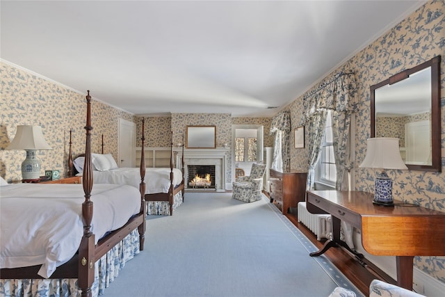 bedroom with a high end fireplace, crown molding, and carpet