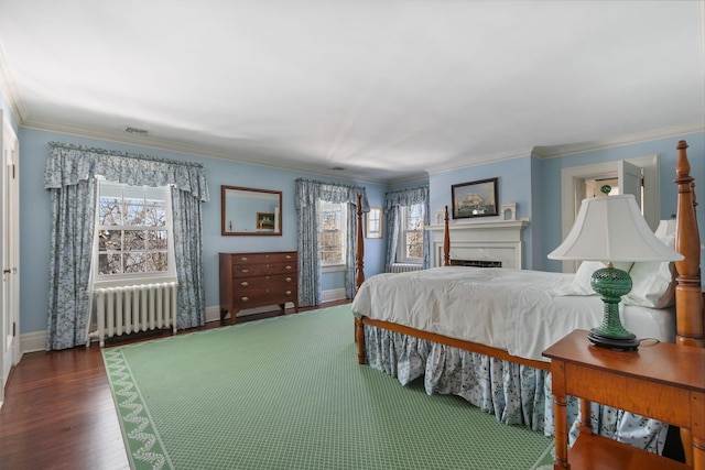 bedroom with crown molding, radiator, and dark hardwood / wood-style flooring