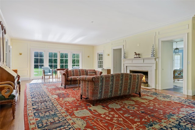 36 Revolutionary Rd, Briarcliff Manor, NY 10510 - living area with a lit fireplace, wood finished floors, healthy amount of natural light, a decorative wall, and ornamental molding