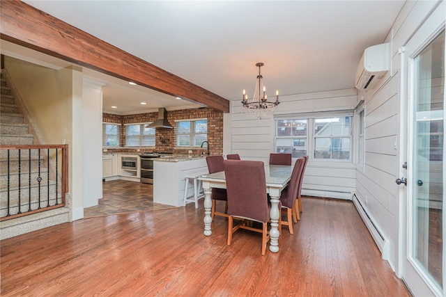 dining area featuring beam ceiling, a baseboard radiator, dark hardwood / wood-style flooring, a notable chandelier, and a wall mounted AC