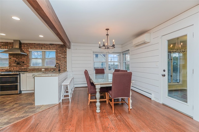 dining room with an inviting chandelier, an AC wall unit, hardwood / wood-style flooring, a baseboard radiator, and beam ceiling