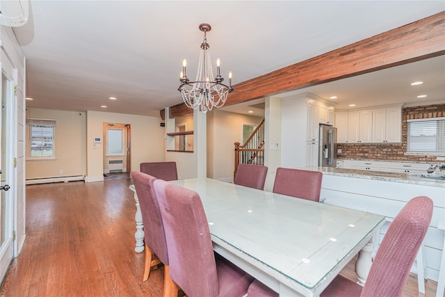 dining area featuring radiator heating unit, beamed ceiling, a baseboard heating unit, a chandelier, and light hardwood / wood-style floors