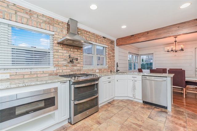 kitchen featuring white cabinets, wall chimney exhaust hood, appliances with stainless steel finishes, beamed ceiling, and decorative light fixtures