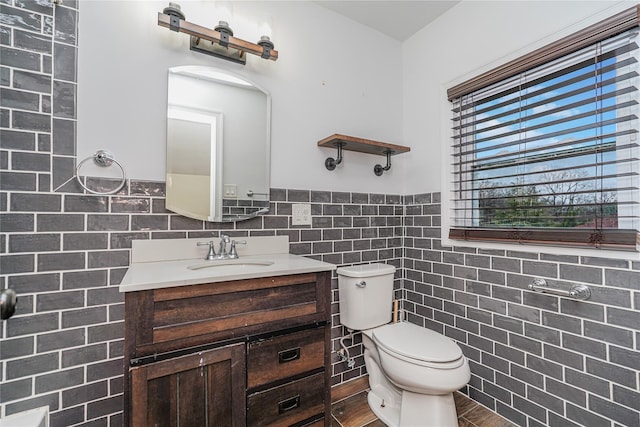 bathroom with wood-type flooring, vanity, and tile walls