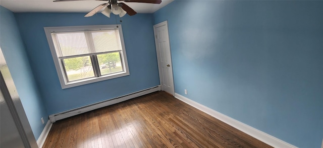 spare room featuring ceiling fan, dark hardwood / wood-style flooring, and a baseboard heating unit