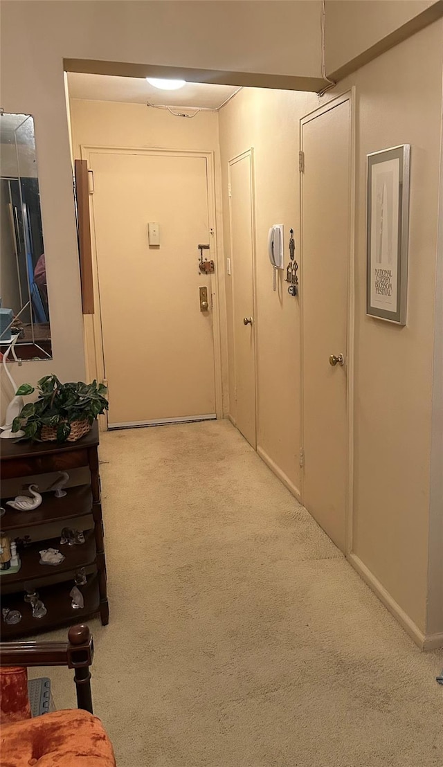 hallway featuring light colored carpet