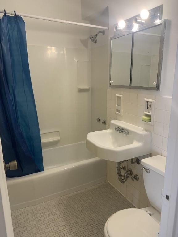 full bathroom with shower / bath combo, sink, tile walls, tile patterned flooring, and toilet