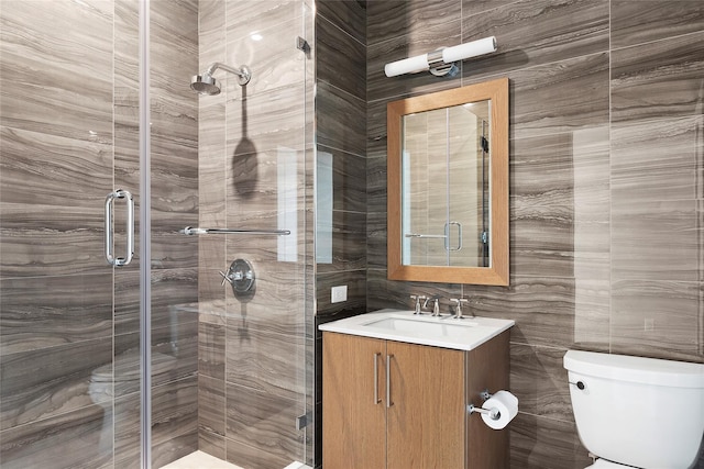 bathroom with toilet, a shower with shower door, and vanity