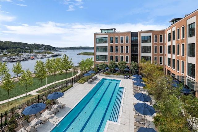 view of pool with a patio and a water view