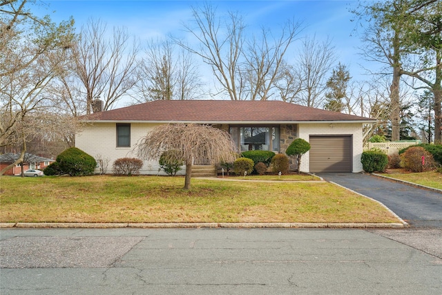 ranch-style house featuring a garage and a front lawn