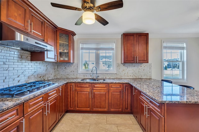 kitchen featuring stainless steel gas stovetop, backsplash, sink, light stone counters, and extractor fan