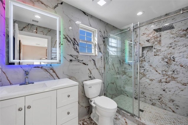 bathroom featuring vanity, toilet, a shower with door, and tile walls