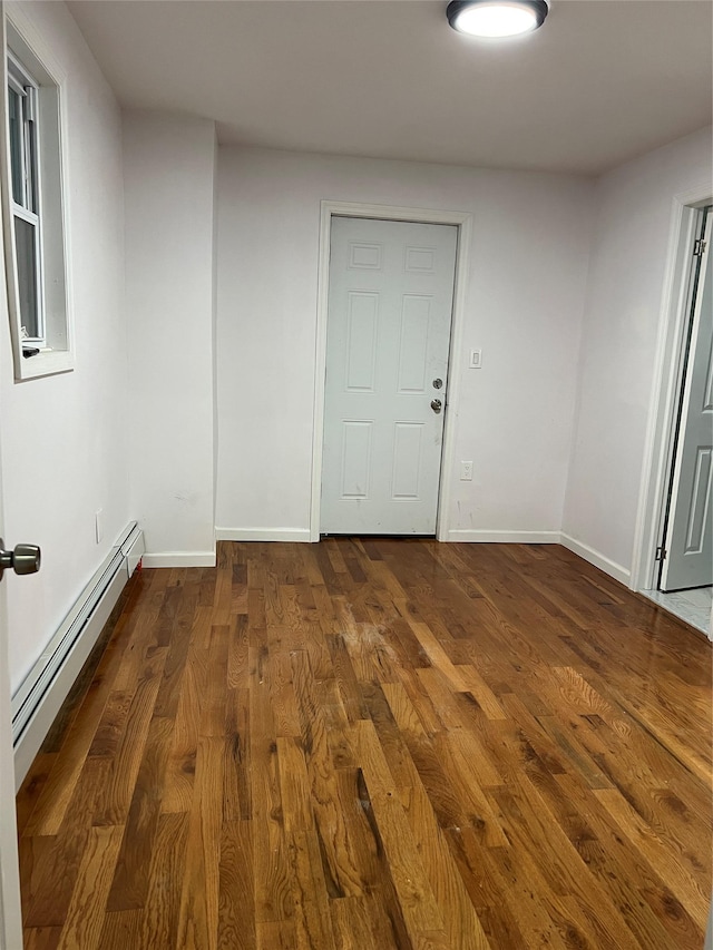 unfurnished room featuring dark hardwood / wood-style flooring and a baseboard radiator