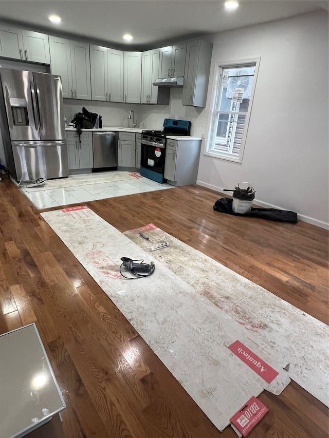 kitchen featuring appliances with stainless steel finishes, light hardwood / wood-style floors, gray cabinets, and sink