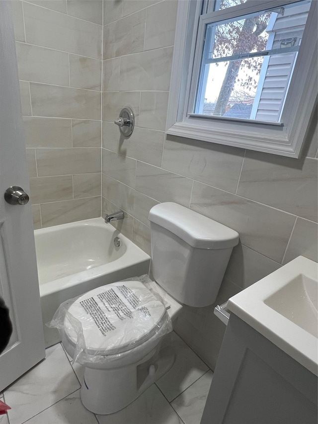 full bathroom with vanity, shower / bath combination, toilet, and tile walls