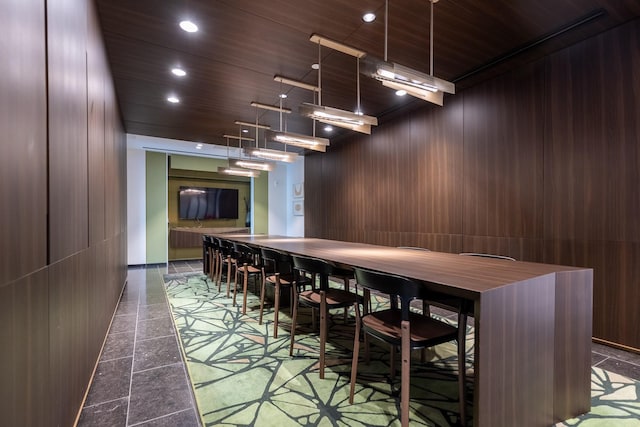 bar featuring decorative light fixtures, wooden walls, and wood ceiling