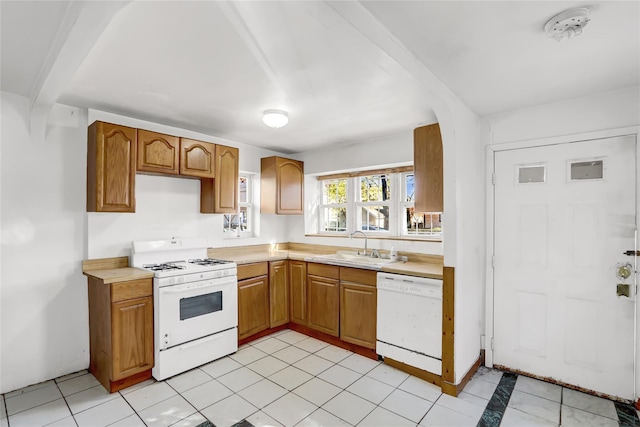 kitchen with sink, light tile patterned flooring, and white appliances