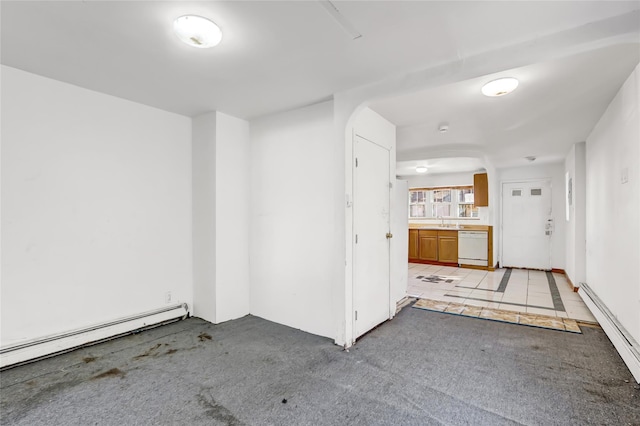 carpeted spare room featuring sink and a baseboard radiator