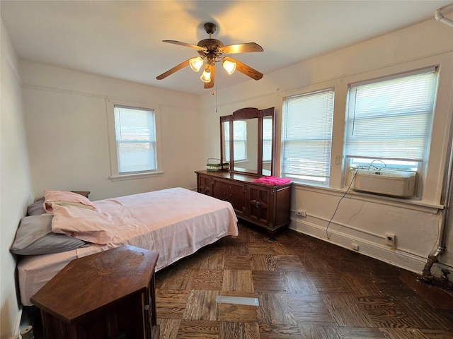 bedroom with ceiling fan and dark parquet floors