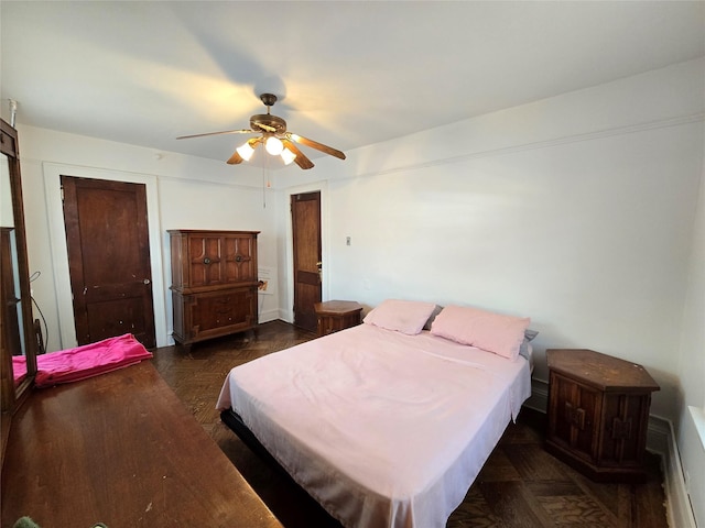 bedroom with dark parquet floors and ceiling fan