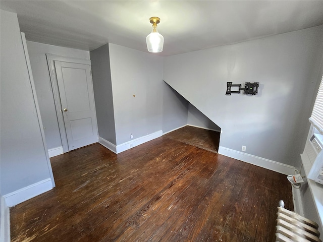 unfurnished living room with dark hardwood / wood-style floors and radiator