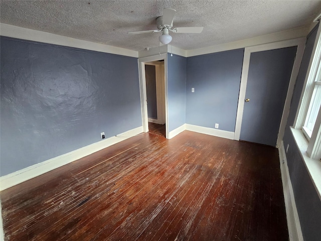 empty room featuring a textured ceiling, dark hardwood / wood-style floors, and ceiling fan