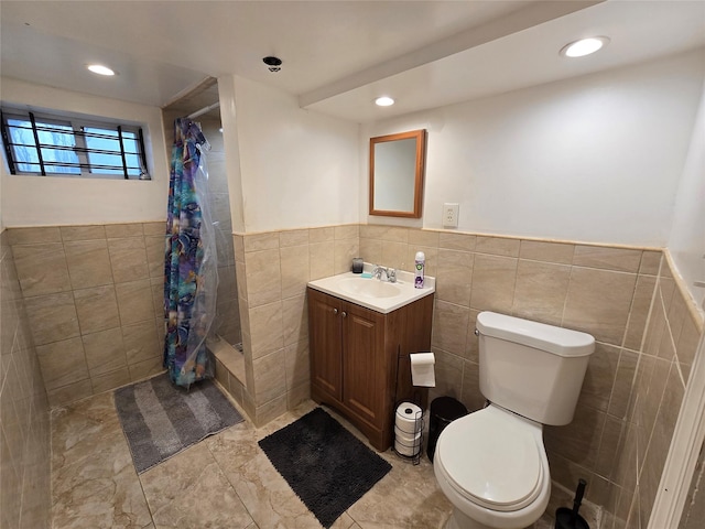 bathroom featuring toilet, vanity, tile walls, and a shower with shower curtain