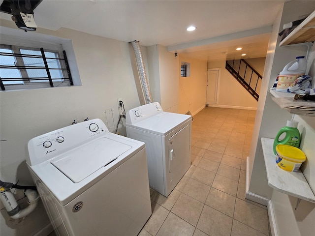 laundry area with washer and clothes dryer and light tile patterned floors