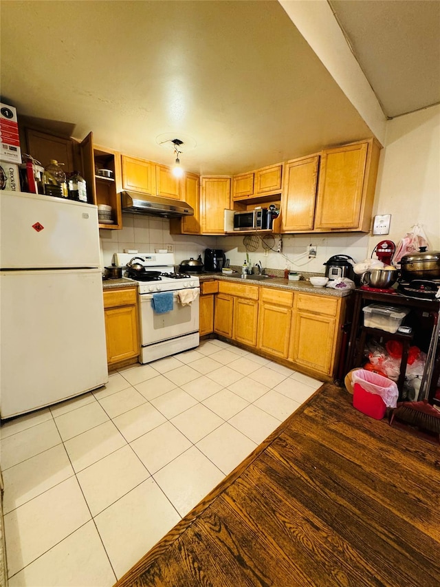 kitchen featuring decorative backsplash, sink, light tile patterned flooring, and white appliances