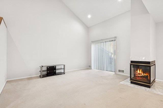 unfurnished living room with carpet flooring, a multi sided fireplace, and high vaulted ceiling