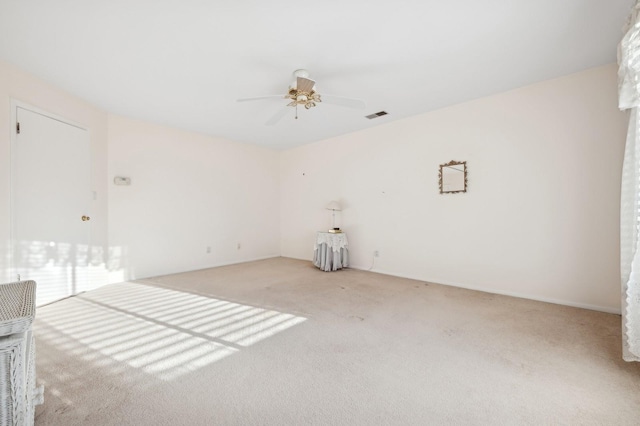 spare room featuring light carpet and ceiling fan