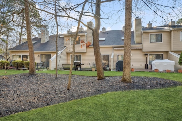 rear view of house featuring a yard and a patio