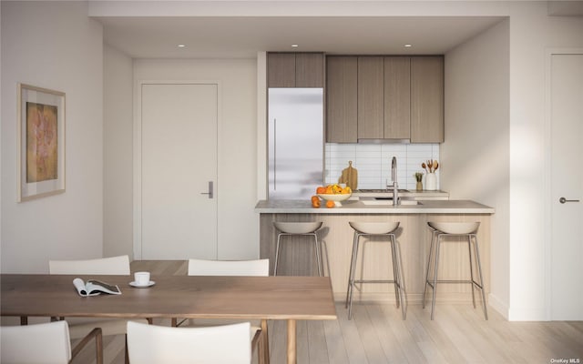 dining area with sink and light hardwood / wood-style floors