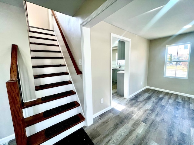 stairs with wood-type flooring and sink