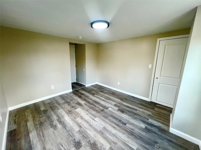 empty room with dark hardwood / wood-style flooring