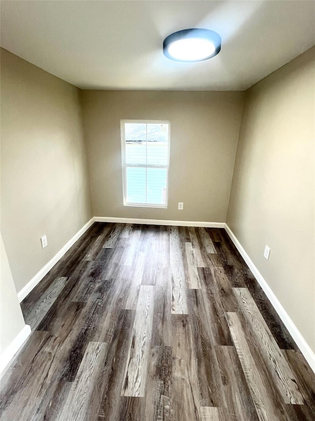 empty room with dark hardwood / wood-style flooring