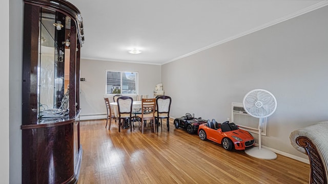 dining space with a wall unit AC, hardwood / wood-style floors, and ornamental molding