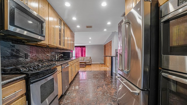 kitchen featuring backsplash, sink, and appliances with stainless steel finishes