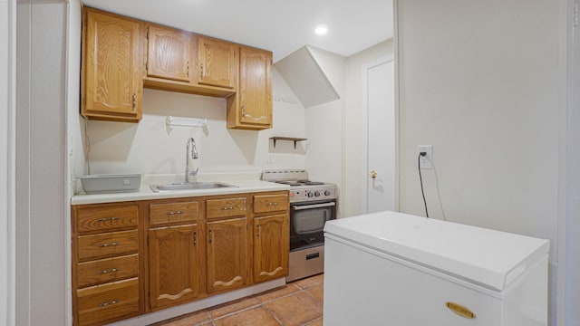 kitchen featuring sink, light tile patterned floors, extractor fan, fridge, and stainless steel stove