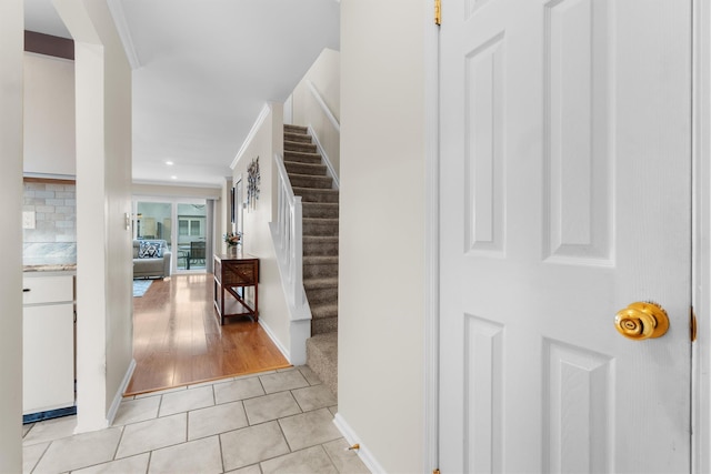 entrance foyer featuring light tile patterned floors and crown molding