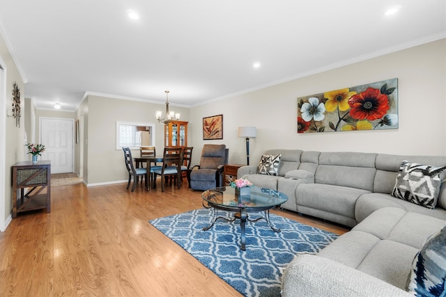 living room with light hardwood / wood-style floors, crown molding, and a chandelier