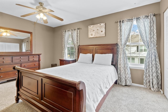 carpeted bedroom with multiple windows and ceiling fan