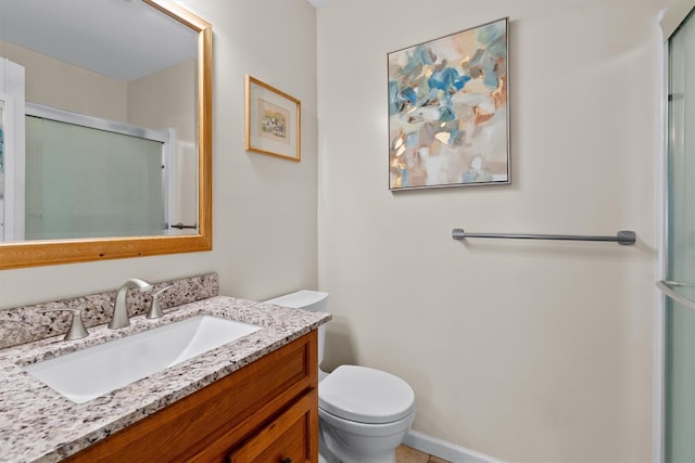 bathroom featuring an enclosed shower, vanity, and toilet