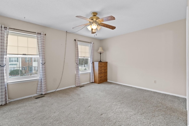 spare room featuring carpet flooring, ceiling fan, and a healthy amount of sunlight