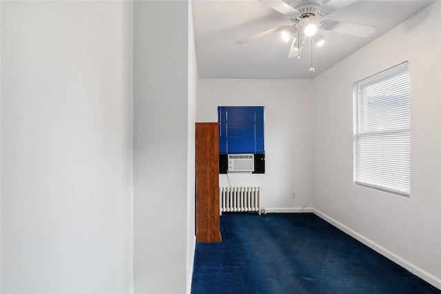 spare room featuring ceiling fan, radiator heating unit, cooling unit, and dark carpet