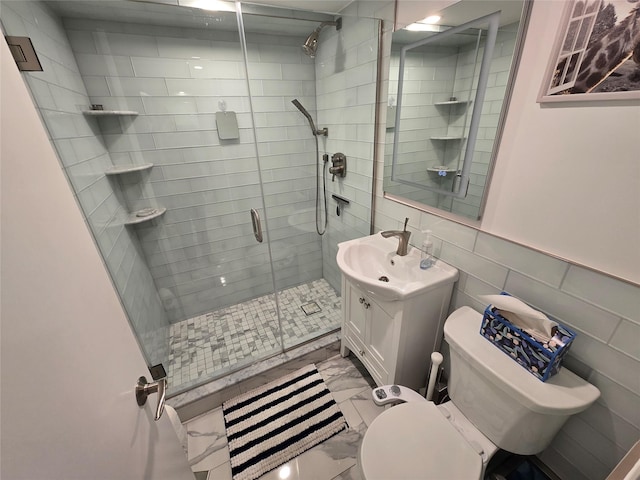 bathroom featuring vanity, a shower with shower door, tile walls, and toilet