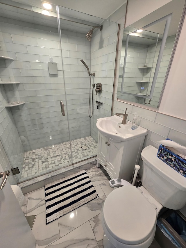 bathroom featuring vanity, a shower with shower door, tile walls, and toilet