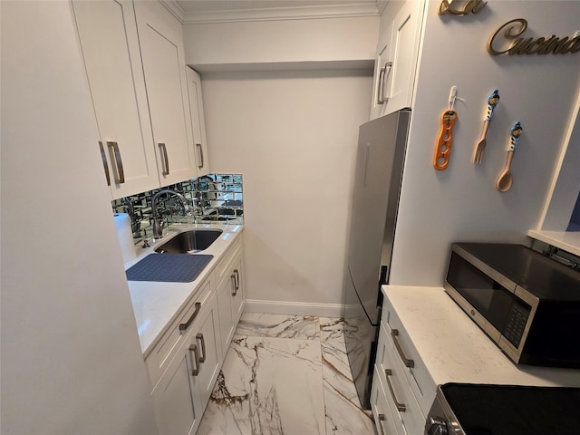 kitchen featuring white cabinets, stainless steel appliances, light stone counters, and sink