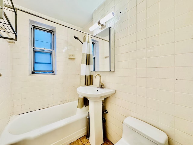 bathroom with tile patterned floors, shower / bath combination with curtain, toilet, and tile walls